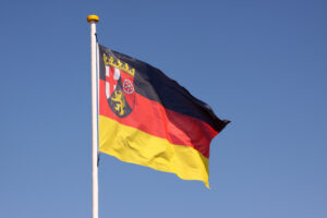 Die rheinland-pfälzische Landesfahne weht vor blauem Himmel.