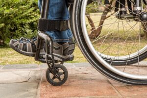 Ausschnitt eines Rollstuhls auf Plasterweg eines Gartens